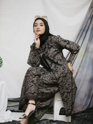 a woman sitting on a chair in a black dress